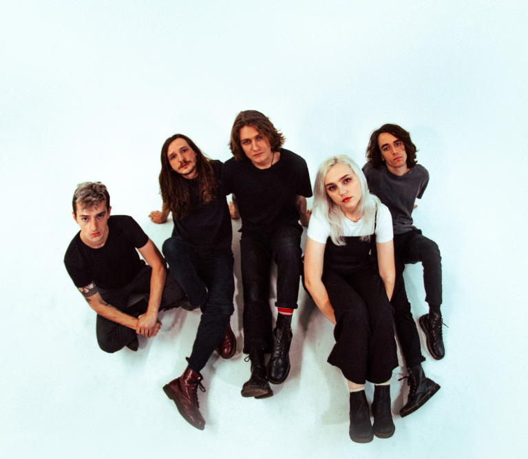 A photograph of the five members of Flipturn sitting against a white backdrop.