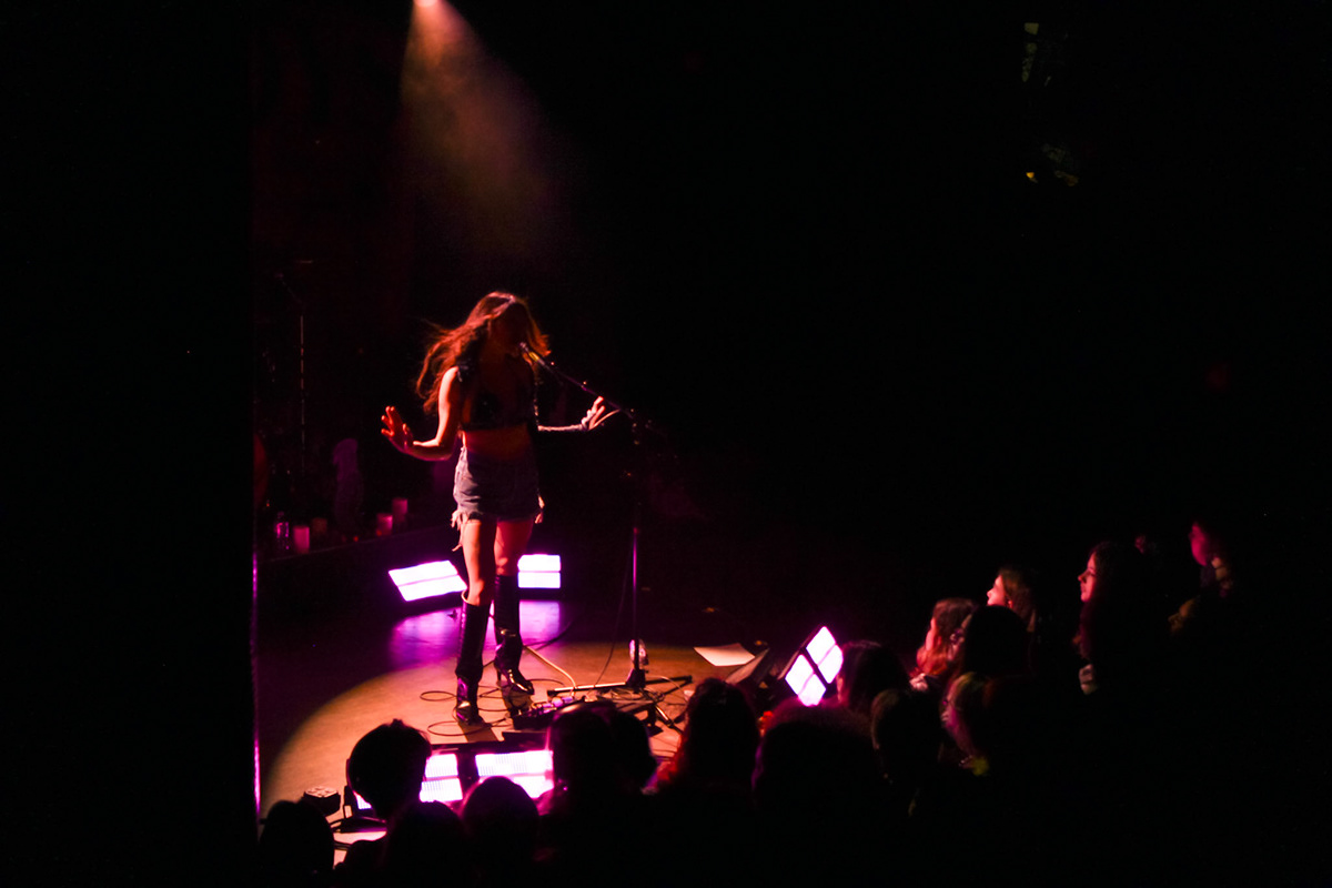 SASMI's silhouette dances before an enthusiastic audience.