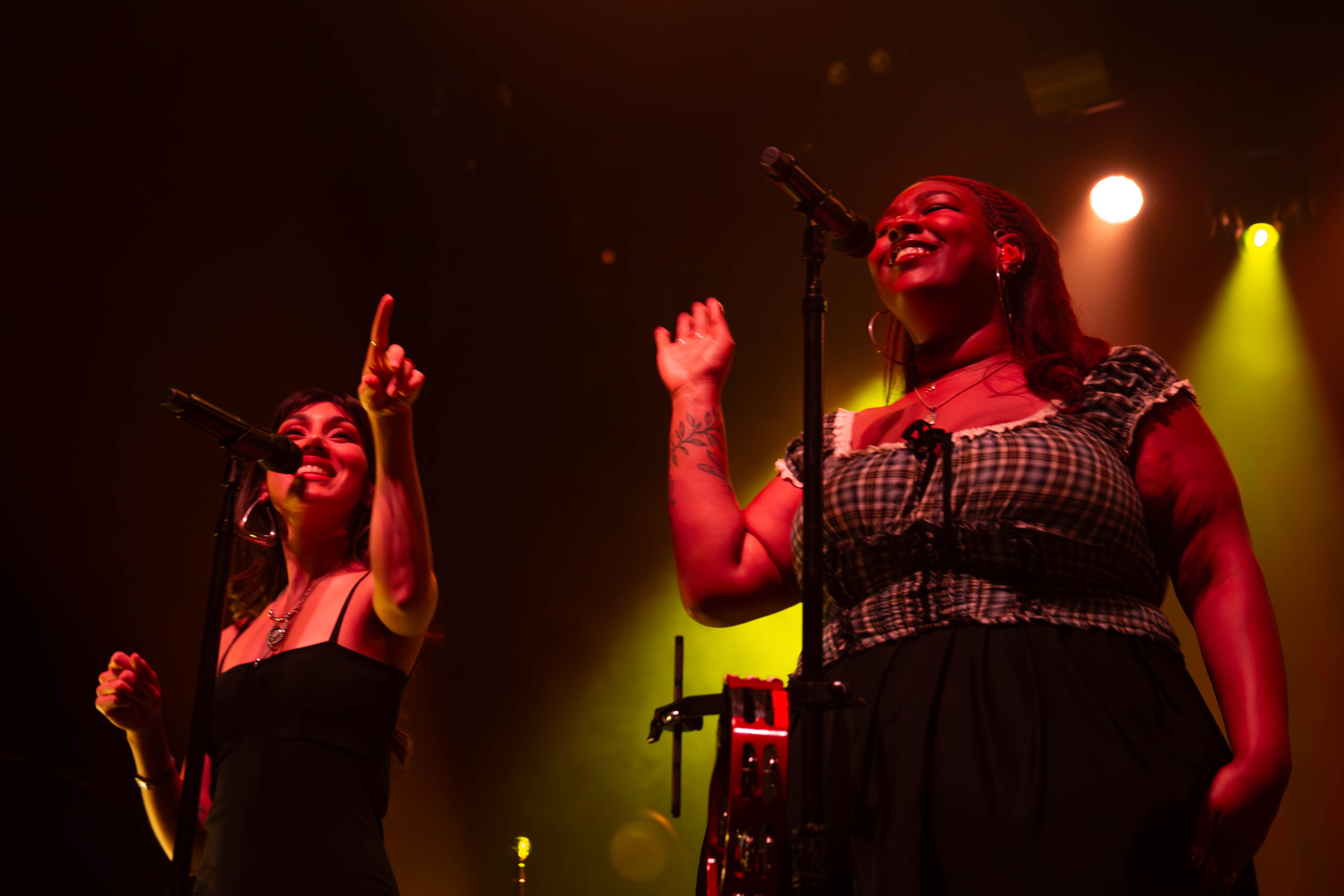 Two backup singers for Thee Sacred Souls dance and sing as they perform enthusiastically.