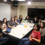 The writing team at WERS sitting around a conference table.