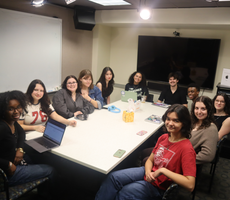 The writing team at WERS sitting around a conference table.