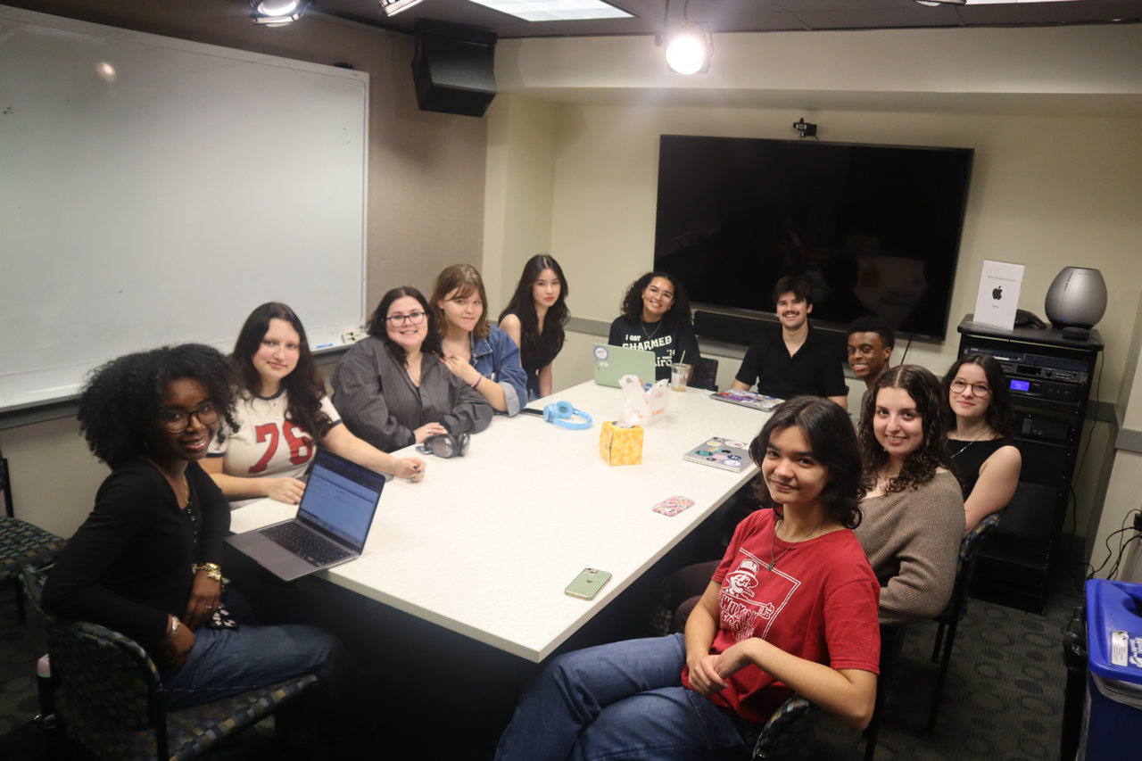 The writing team at WERS sitting around a conference table.