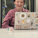 Nora with her laptop and three calico critters.