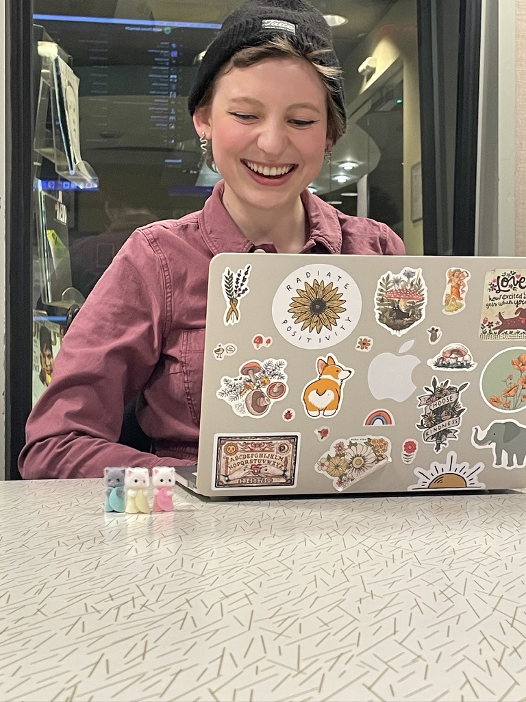 Nora with her laptop and three calico critters.