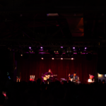 Katie Gavin plays guitar in front of red lighting at Brighton Music Hall