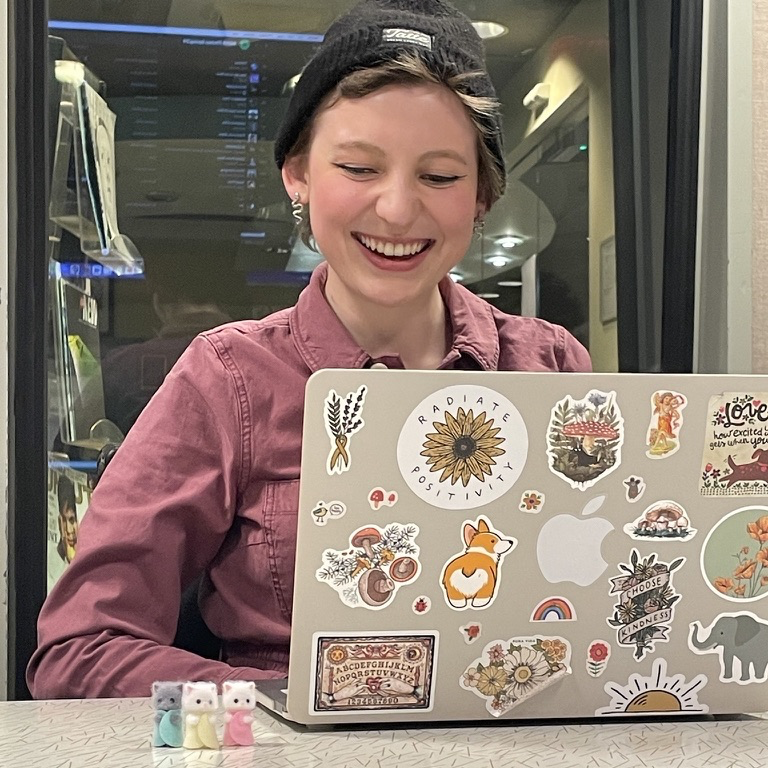 Nora with her laptop and three calico critters.