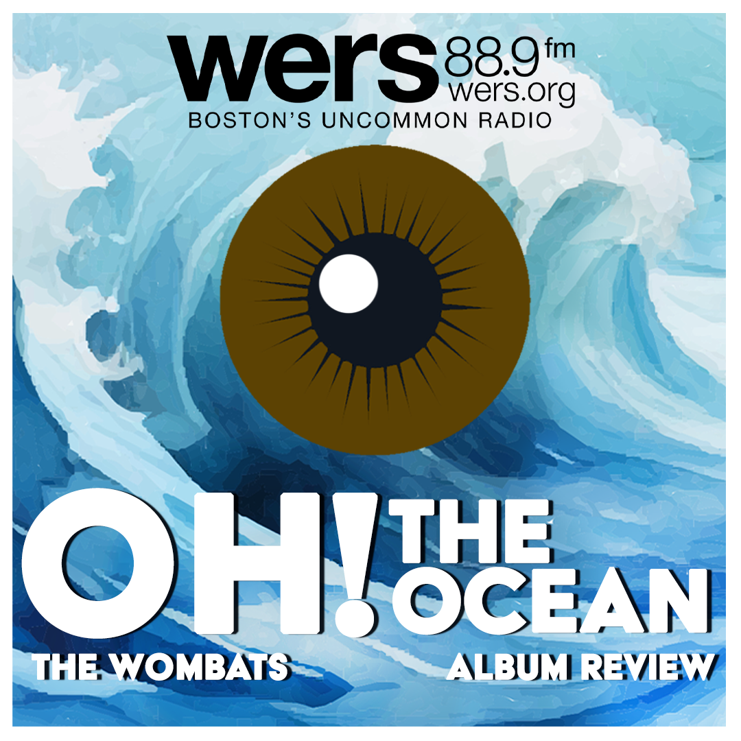 Waves crash behind a floating brown eyeball, reflecting the cover of the Wombats album "Oh! The Ocean." White txt reads "The Wombats," Album Review" and "Oh! The Ocean."