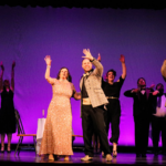 A wide shot of the production of Prom at Wide Open, with a purple backdrop.