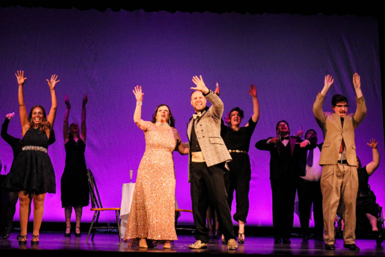 A wide shot of the production of Prom at Wide Open, with a purple backdrop.