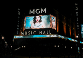 A photo of the outside of MGM Music Hall featuring Lucy Dacus on a large screen.